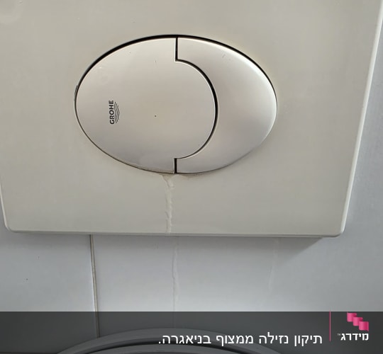 לחצן הדחה של אסלה על קיר אריחים לבנים